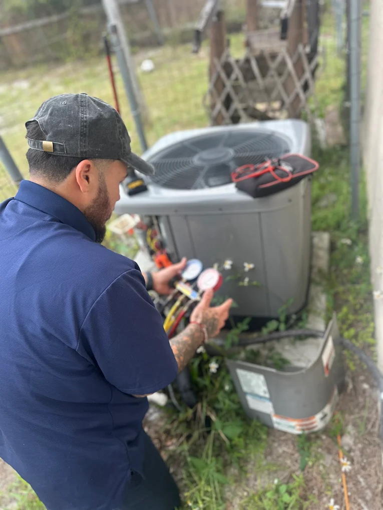 Enrique Torres, Premier Frost owner and lead HVAC technician, servicing an air conditioning unit